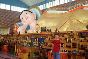 Erik bij een reusachtig beeld in de Thaise tempel