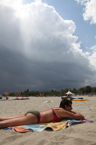Donkere wolken en een zonovergoten strand